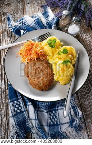 Homemade Minced Meat Cutlet Served With Mashed Potatoes And Carrot Salad.