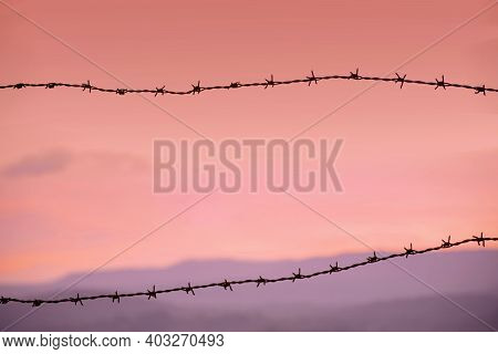 Background Of Metallic Boundary Wire Silhouette During The Evening With Colorful Sky. Used Selective