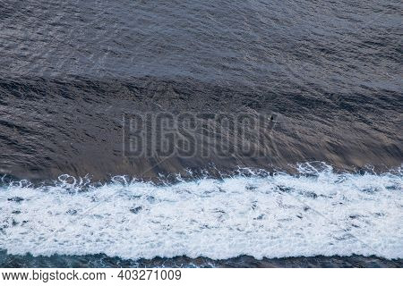 Aerial View Of Ocean With Wave And Lonely Surfer In Blue Water