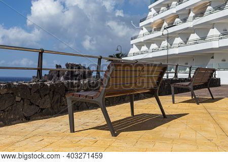 A Couple Of Benches At The Promenade With Sea View On Sunny Day.