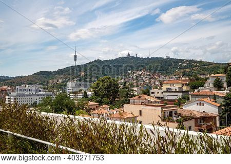 View From A Rooftop Of Typical Living Area In Barcelona With Antenna And Mountain At The Background.