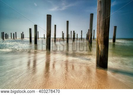 Long Exposure Seascape. Taken At The North Sea In Petten With The Pole Village In The Sea, Blue Sky,