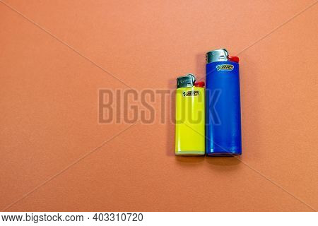 Miercurea Ciuc, Romania-14 January 2021: Blue And Yellow Bic Cigarette Lighters On Orange Background