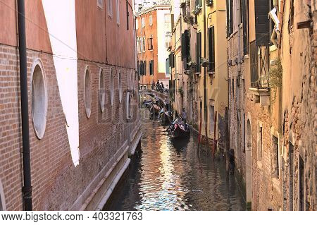 Venice, Italy - 5 August, 2016: Tourists Enjoying The Gondolas In A Canal. The Gondolas Are The Most