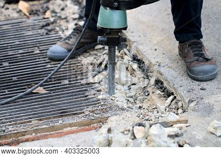 Male Workers Use Electric Concrete Breaker For Digging And Drilling Concrete Repairing Driveway Surf