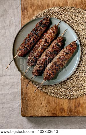Eastern Fast Food. Grilled Beef Lyulya Kebab On Sticks On Ceramic Plate On Wooden Table With Round S