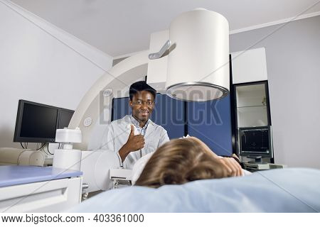 Portrait Of Young Smiling African American Man Doctor, Looking At Camera With Thumb Up, While Provid