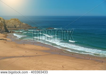 Delightful Panoramic View Of The Portuguese Beach Odeceixe With Tourists At The Sea.