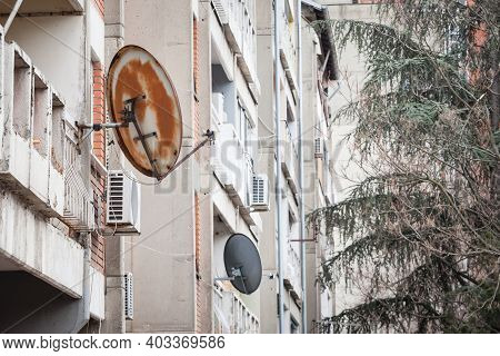 Rusty Satellite Dish Tv Uhf Antennas On Display At The Top Of A Traditionnal Communist Housing In Th