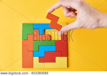 Logical Thinking And Finishing Task Concept. Woman Hand Adding Last Missing Wooden Block To Finish A