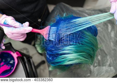 Top View Of Hair Coloring In Beauty Salon. Hairdresser In Protective Glove Using Pink Brush While Ap