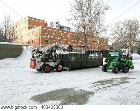 Moscow. Russia. January 15, 2021. Small Front-end Loaders Clear Snow From The Street And Load Into A