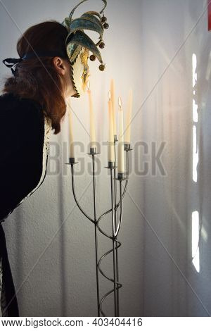 Art Concept. Person Disguised With Venetian Mask Beside Lighted Candles