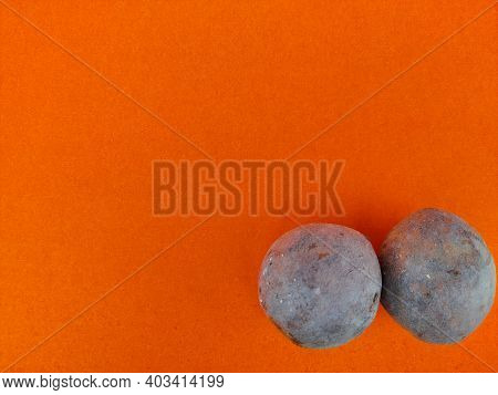 Copy Space Of Orange Background With Two Sapodilla Or Chikoo In Corner.