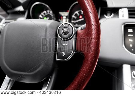 Cruise Control Buttons On The Red Perforated Leather Steering Wheel Of A Modern Car.  Car Interior D