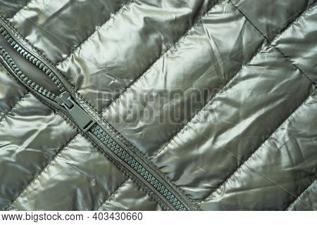 Close-up Zipper Closure On A Light Warm Jacket Of Olive Color. Warm Clothes, Accessories For Outerwe