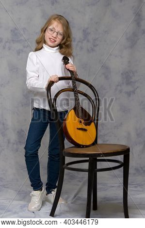 Cute Little Girl Learning To Play The Plucked Musical Instrument, Domra.