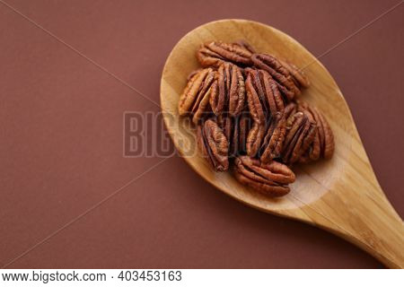 Pecan Nut Close-up In Spoon On Bright Brown Background.healthy Fats.heap Shelled Pecans Nut Closeup.