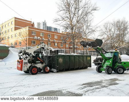 Moscow. Russia. January 15, 2021. Small Front-end Loaders Clear Snow From The Street And Load Into A