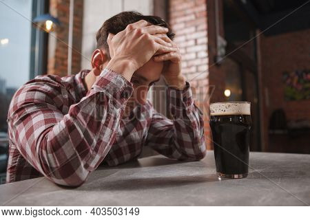 Depressed Man Drinking Alone At Beer Pub