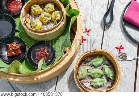 Dimsum Hagao In Chinese Bamboo Basket. Gyoza On A Wooden Table In A Restaurant. Assorted Asian Food 