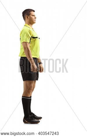 Full length profile shot of a serious footall referee isolated on white background