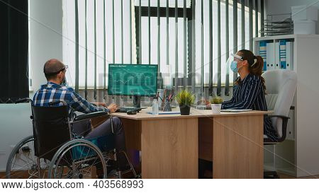 Manager With Disability Comming With Wheelchair At Workplace With Protection Mask Working In New Nor