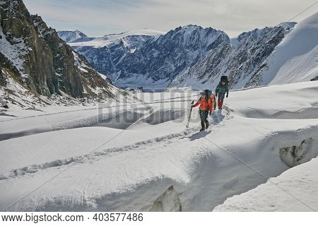 Two climbers walking on glacier with crevasse