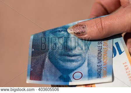 World Money Concept, Close Up Of 100 Swiss Franc Banknote, Photo Of Chf Currency Isolated. Hand Hold