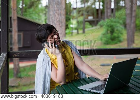 Young Woman Working On Computer From Home Office From A Cabin Or Cottage.