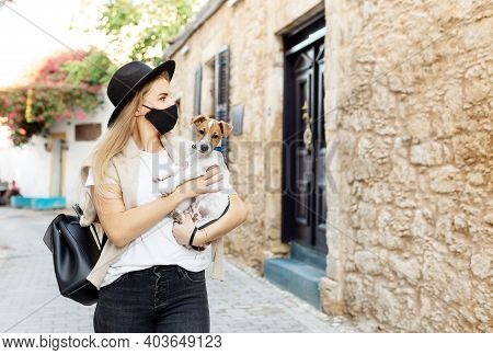 Portrait Of A Small Dog Jack Russell Terrier, Sitting On The Knees Of An Adult Female Owner, While H