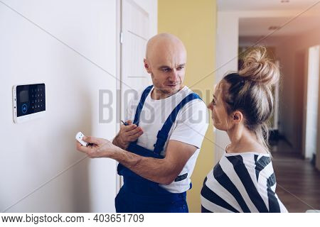 The Woman Is Learning How To Handle The Alarm. Security At Home