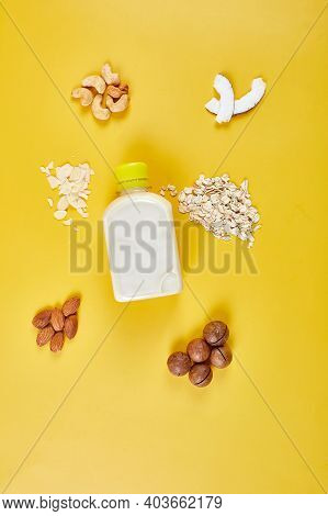 Alternative Types Of Vegan Milks In Bottles On A Yellow Background
