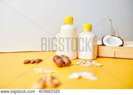 Alternative Types Of Vegan Milks In Bottles On A Yellow Background