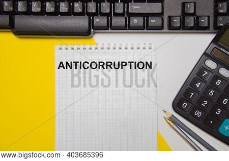 Anticorruption Text Is Written On A White Notebook That Lies On A Yellow Piece Of Paper With A Compu