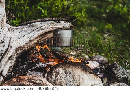 Kettle Hanging Over Fire. Cooking Food At Fire In Wild. Beautiful Big Log Burns In Bonfire Close-up.