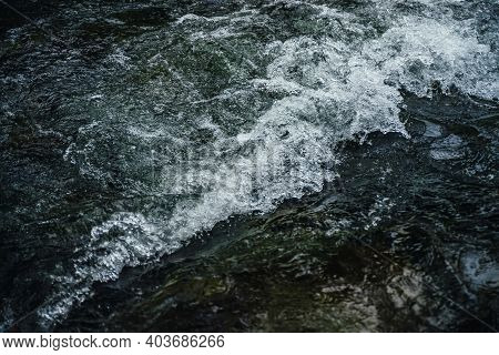 Nature Background Of Dark Water Stream Of Mountain River With Rapids. Full Frame Of Sea Surf. Natura