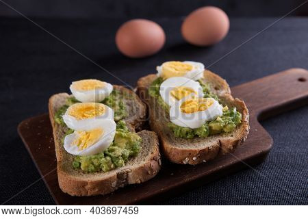 Sandwich Prepared With Oat Toast, Avocado And Boiled Egg, With Dark Backgrounds.