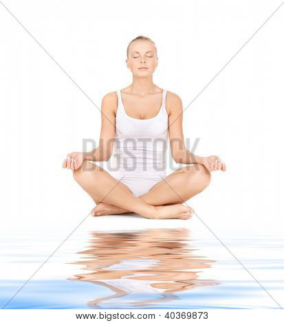 sportliche Frau in Baumwolle Undrewear üben Yoga Lotus darstellen auf weißem sand