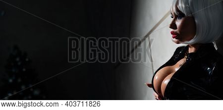 Sexy Woman In A Blonde Wig And Latex Catsuit. Girl With Big Fake Tits