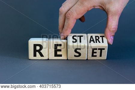 Reset And Restart Symbol. Businessman Hand Turns Cubes And Changes The Word 'reset' To 'restart'. Be