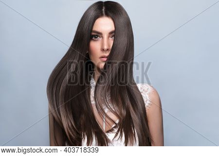 Beautiful Brown-haired Girl With A Perfectly Smooth Hair, And Classic Make-up. Beauty Face And Hair.