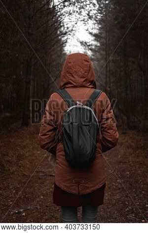 Girl With Backpack From Behind In The Woods With Hoodie
