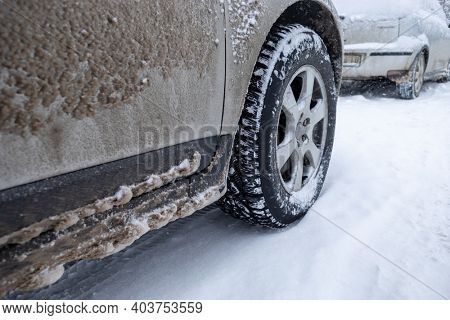 Winter tire. Car on snow road. Tires on snowy highway detail stock photo