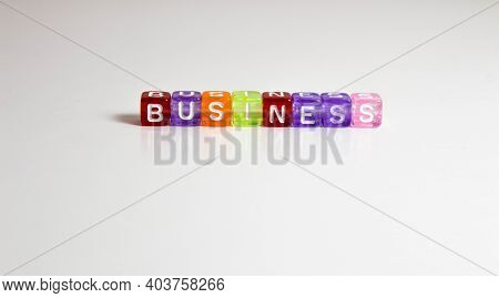 The Word Business Is Written On Colorful Cubes On A Gray Background. Style
