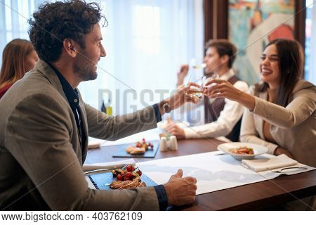 Young business people enjoying business lunch in a relaxed atmosphere at the restaurant. Business, restaurant, lunch