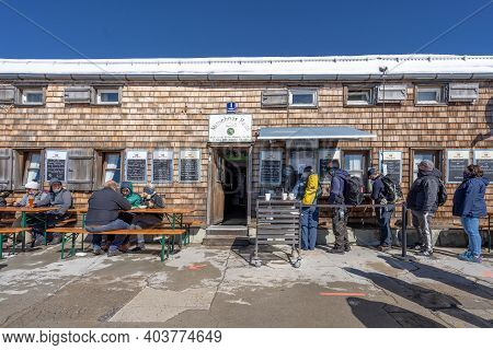 Zugspitze, Germany - Aug 5, 2020: People Wear Mask Queue To Enter Restaruant On Top