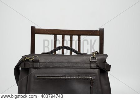 Brown Mens Shoulder Leather Bag For A Documents And Laptop On A Brown Chair With A White Background.