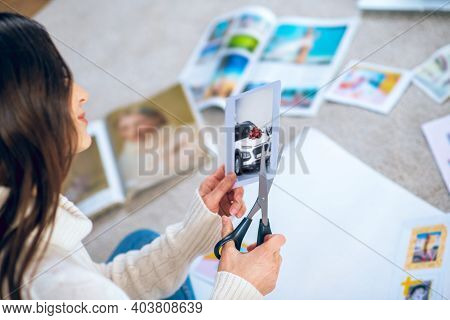 Woman Cutting Pistures From Magazines And Making A Wishlist