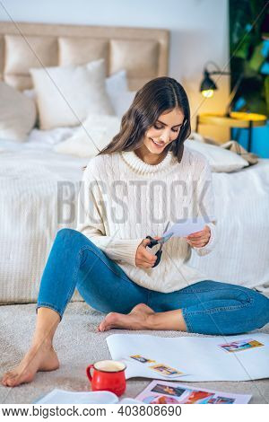 Woman Cutting Pistures From Magazines And Making A Wishlist